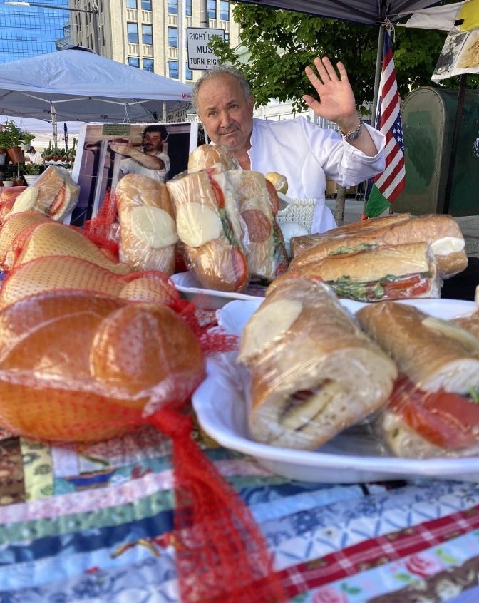 Chef preparing gourmet sandwiches at outdoor market